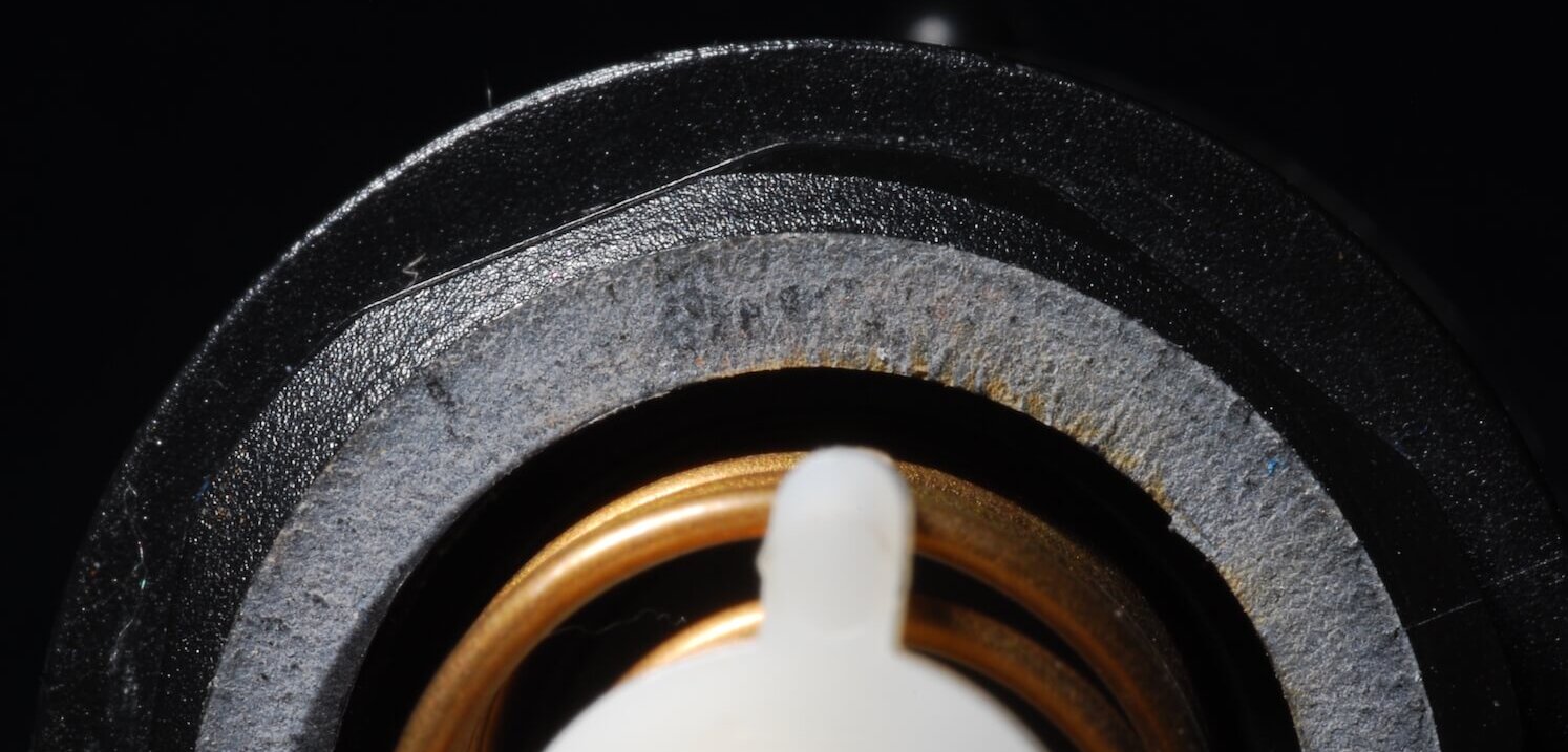 A fracture surface on a threaded fitting created by unsupported piping generating elevated stress on the thread root
